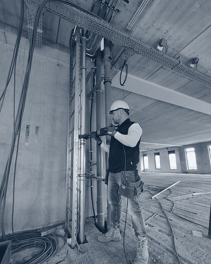 Quinny Horn monteert leidingwerk op een bouwlocatie