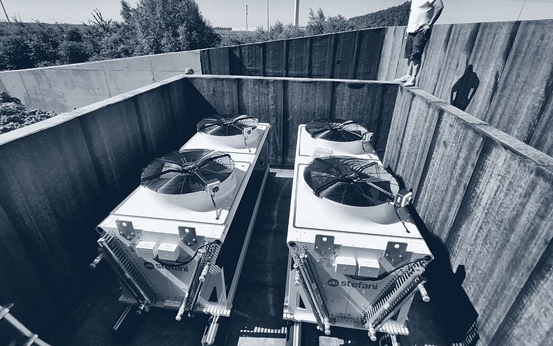 Koelinstallatie met leidingwerk op het dak van een bedrijfsgebouw