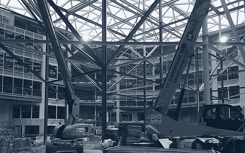 Uitvoering in een grote hal met hoogwerkers onder een stalen dakconstructie